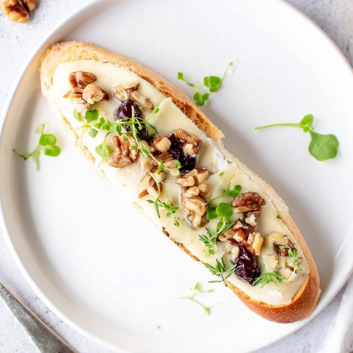 Golden baked Festive Holiday Cranberry and Brie Crostini, topped with vibrant red cranberry sauce.