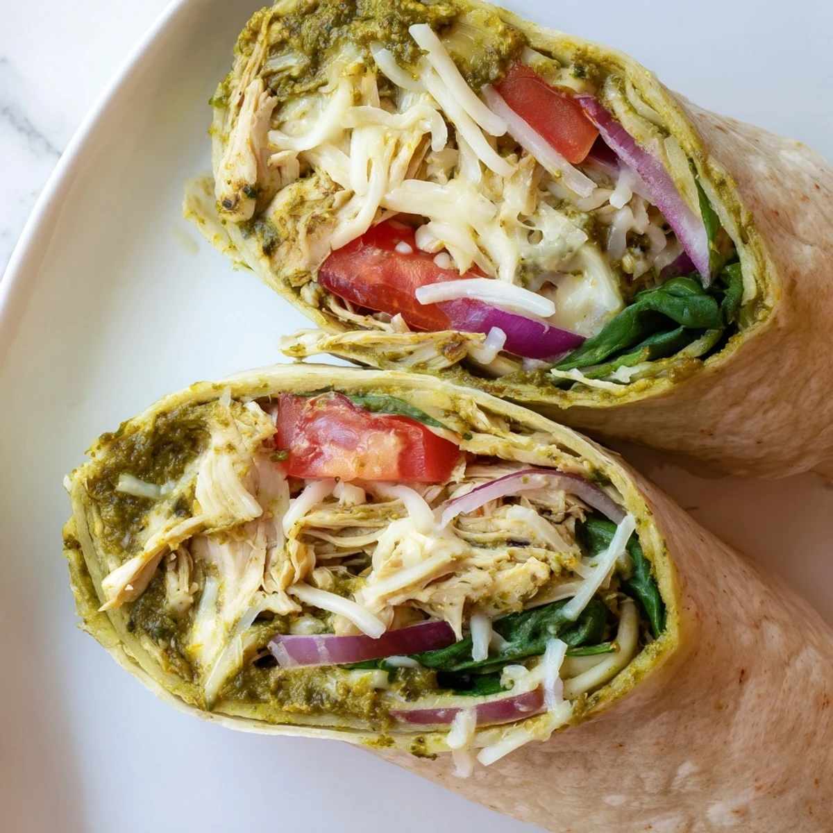 Enjoy a quick lunch with this appetizing pesto chicken wrap, perfectly rolled and ready to eat.