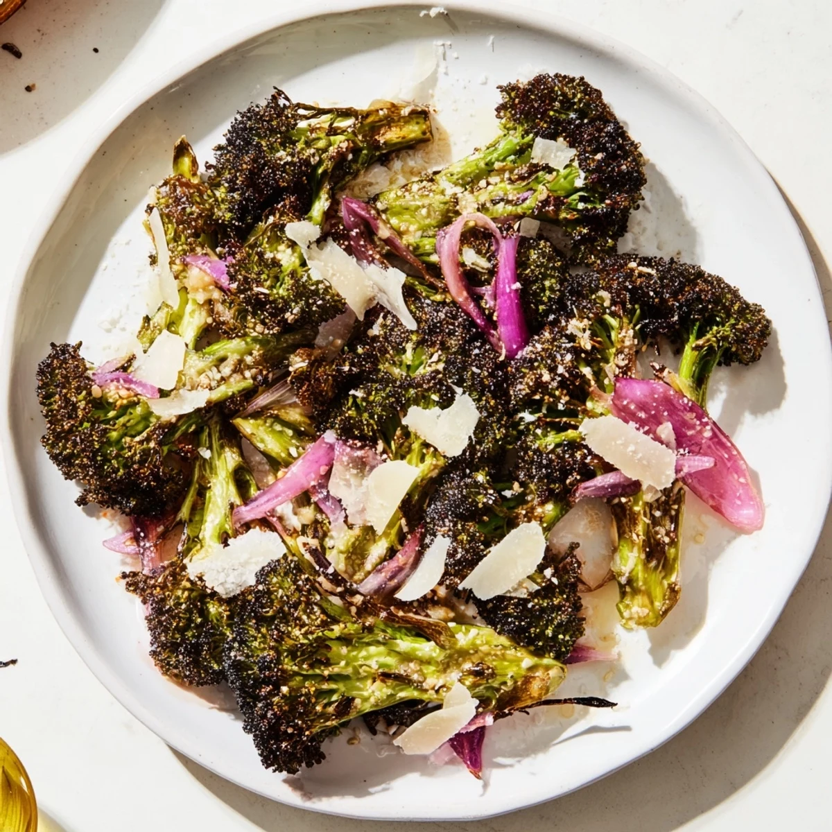 Smoky close-up of Charred Broccoli Salad, Parmesan cheese, and toasted nuts, a delicious side dish.