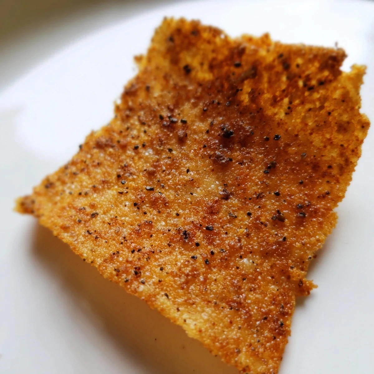 Thin, crunchy Cottage Cheese Chips with a golden edge, arranged on a parchment-lined tray just out of the oven.