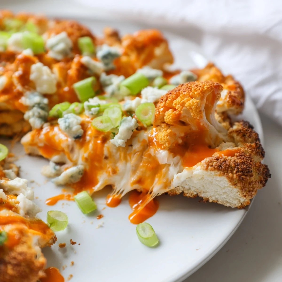 Overhead view of a baked Buffalo Cauliflower Pizza, featuring a gluten-free cauliflower base and vibrant garnish, ready to be enjoyed.