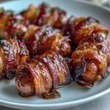 A close-up of Bacon-Wrapped Smokies on a serving platter, perfect party appetizers ready to eat.