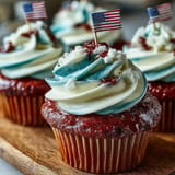 Festive Star-Spangled Banner Cupcakes topped with tiny American flags, perfect for parties.
