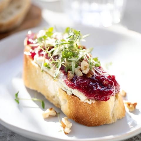 Warm, creamy Brie perfectly melting on toasted baguette slices, part of the Festive Holiday Cranberry Crostini.