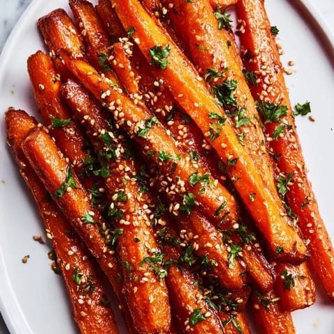Golden-brown Maple Mustard Roasted Carrots arranged on a platter, offering a taste of sweet and savory.