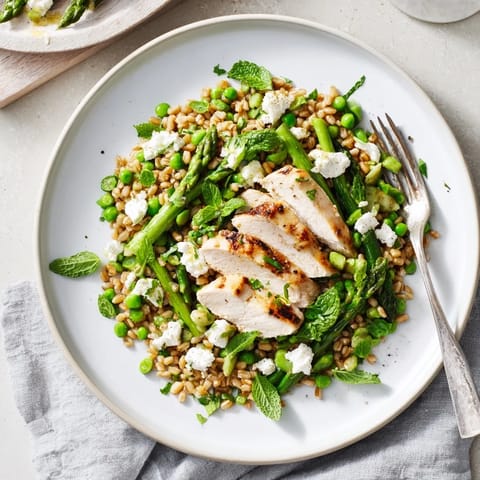 Savory Warm Spring Farro Chicken Salad served warm with crumbled feta and fresh herbs, offering a wholesome meal perfect for springtime lunches.  