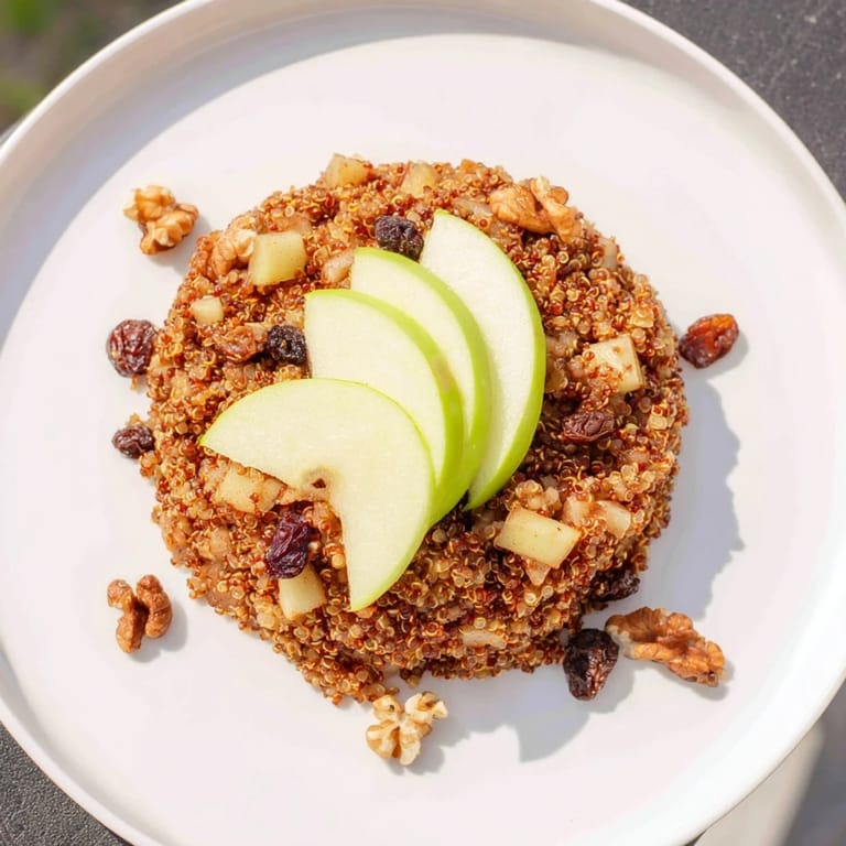 Close-up of a vibrant apple cinnamon quinoa bowl, enticing with cinnamon aroma, topped with crunchy walnuts.