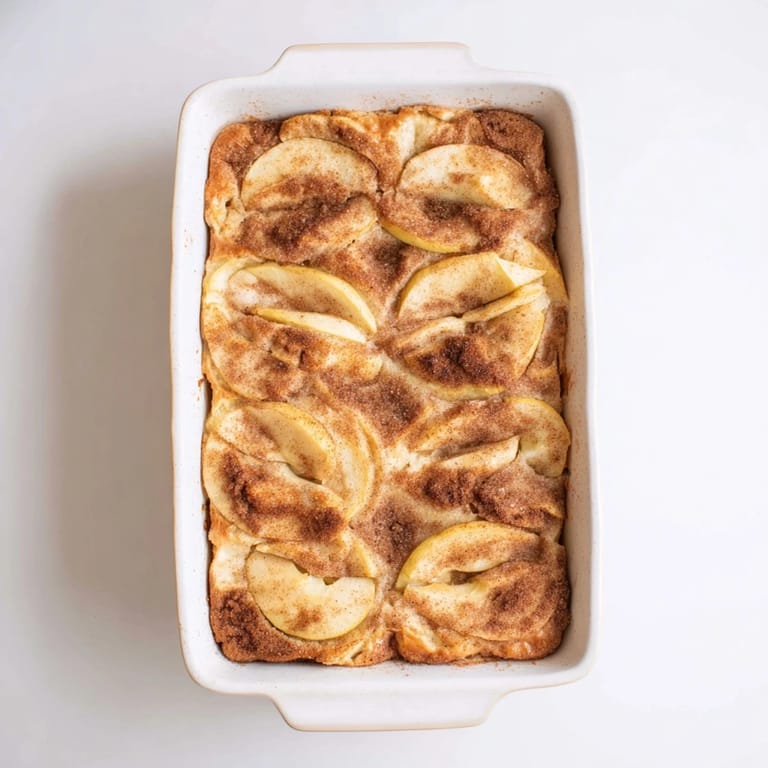 Golden Baked Apple Cake cooling on a rack, with a rich cinnamon aroma and juicy apples in a golden, soft crumb.