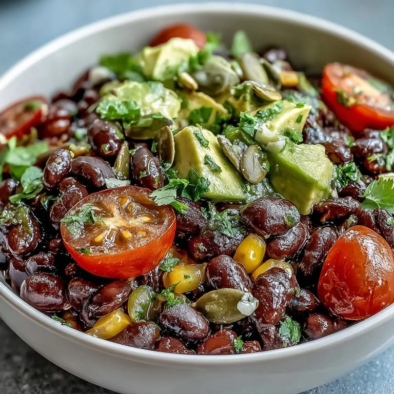 Colorful serving of a Black Bean and Veggie Bowl topped with cilantro and pumpkin seeds, perfect for a healthy lunch.